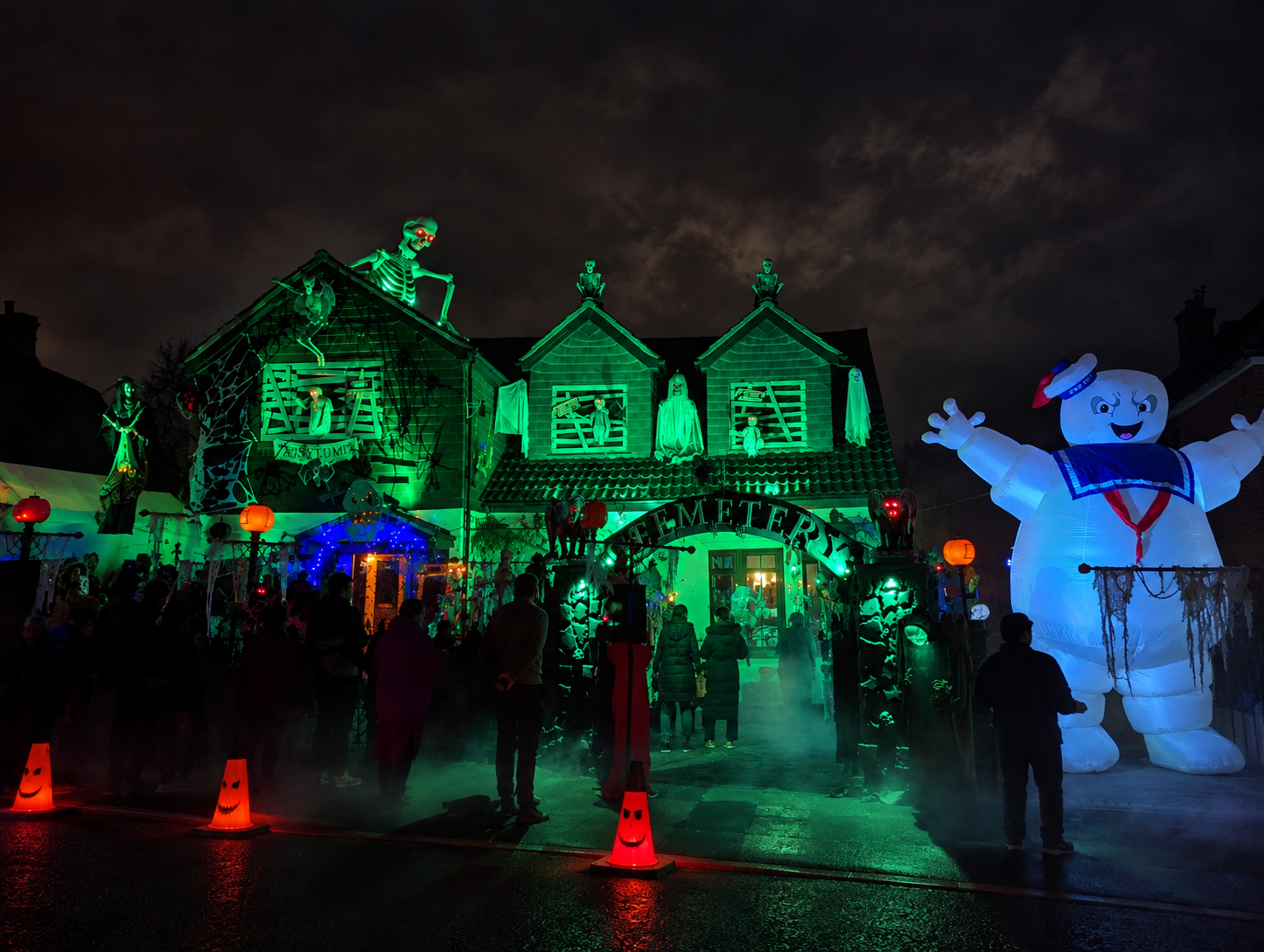 PlantationVille Haunted Manor illuminated for Halloween with visitors outside